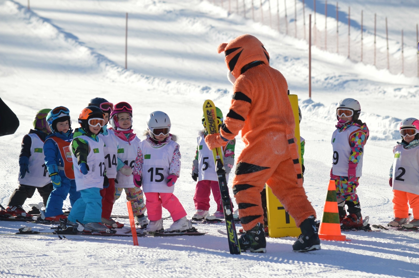 Kinder-Schikurs mit dem Tiger-Maskottchen der Schischule greenorange